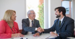 Senior couple shaking hands with an elder law attorney at their first meeting