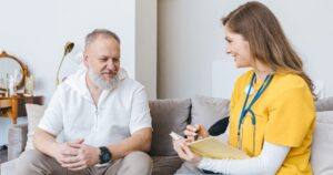 Healthcare worker discussing medical wishes and advance directives with an older patient at home