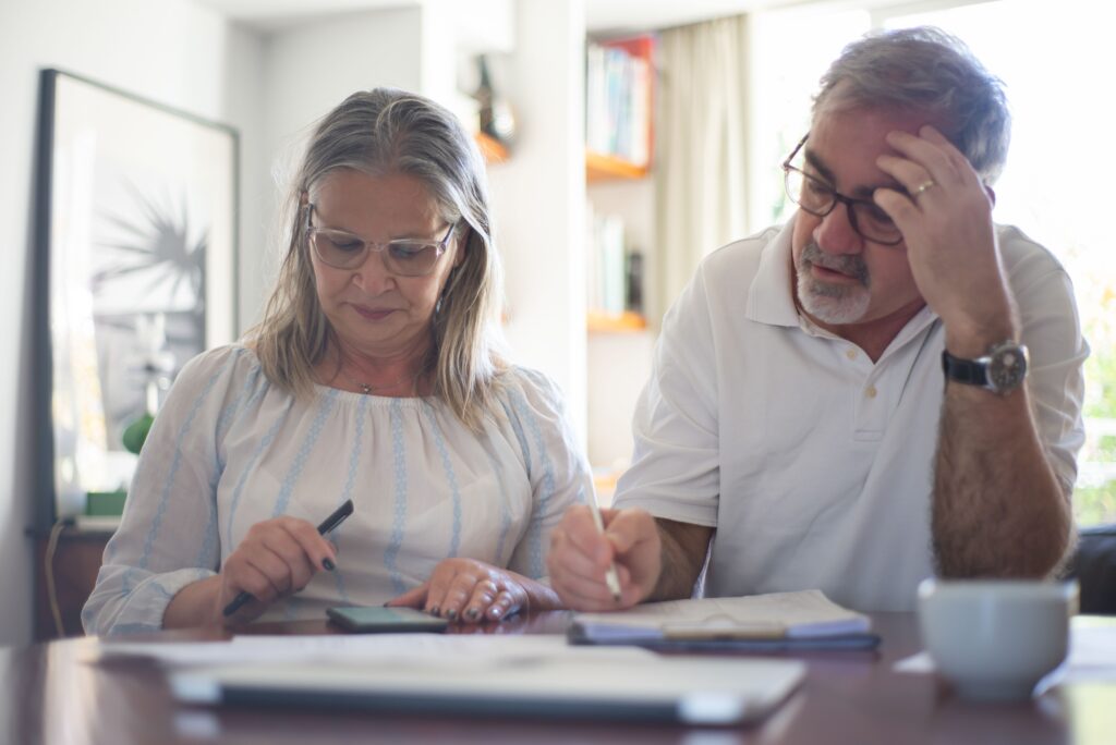 Older couple reviewing financial and healthcare power of attorney documents together at home